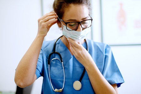 Female doctor wearing mask and scrubs.