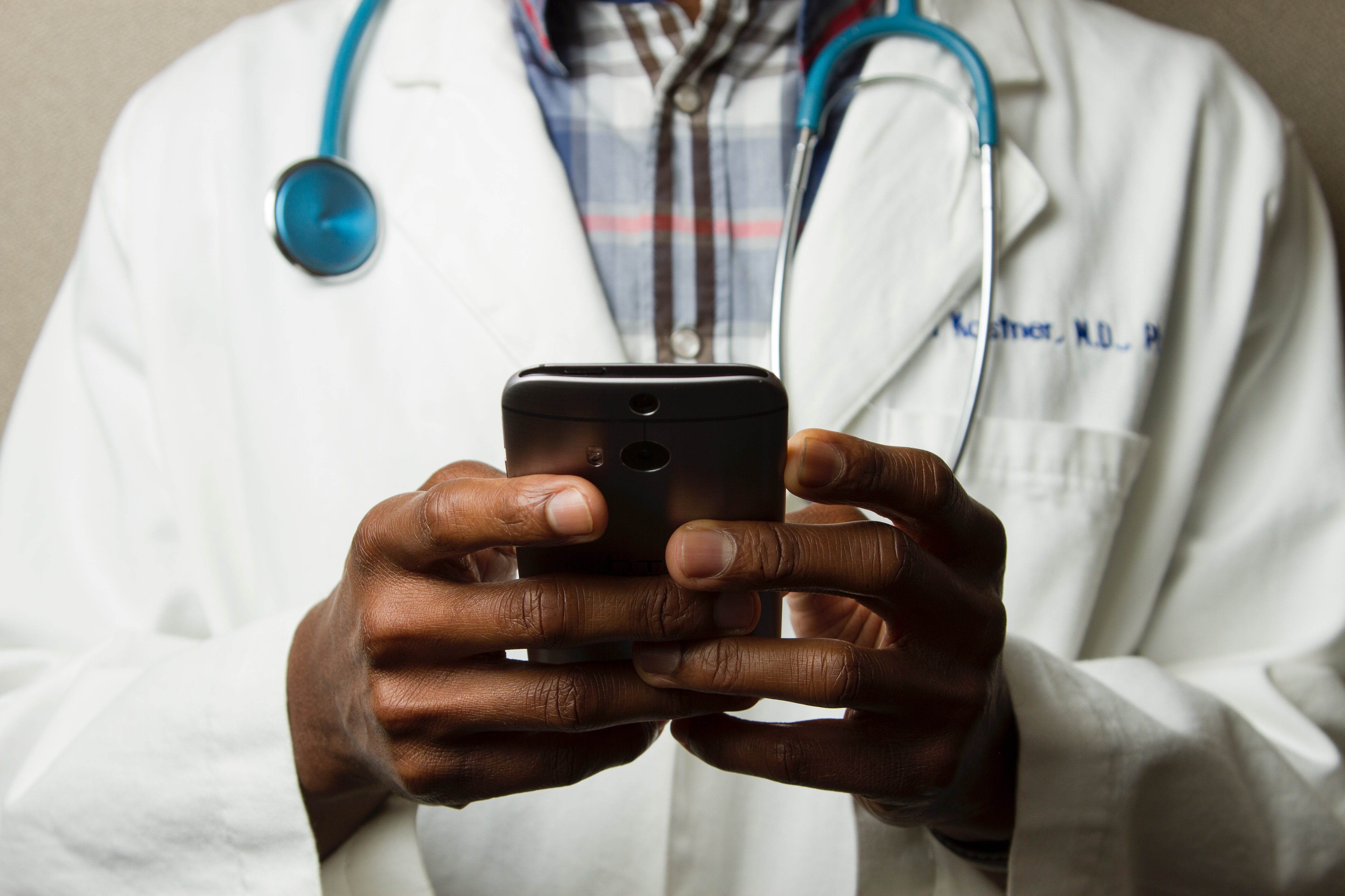 Medical professional texting on a smartphone.