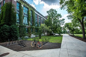 Bike in a bike rack on an empty student campus with buildings and beautiful trees
